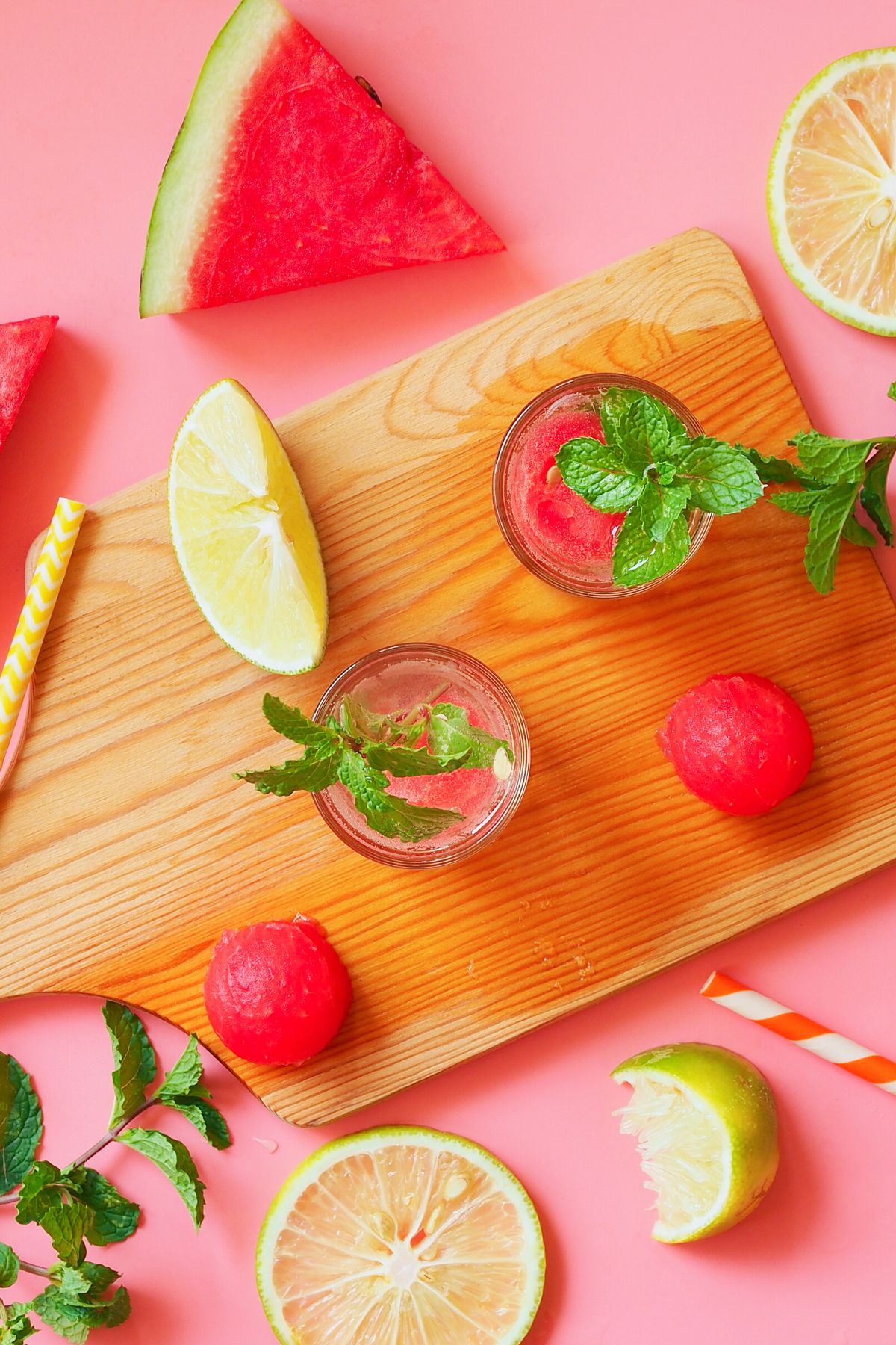 Glasses of watermelon vodka cocktail in glasses on a cutting board.