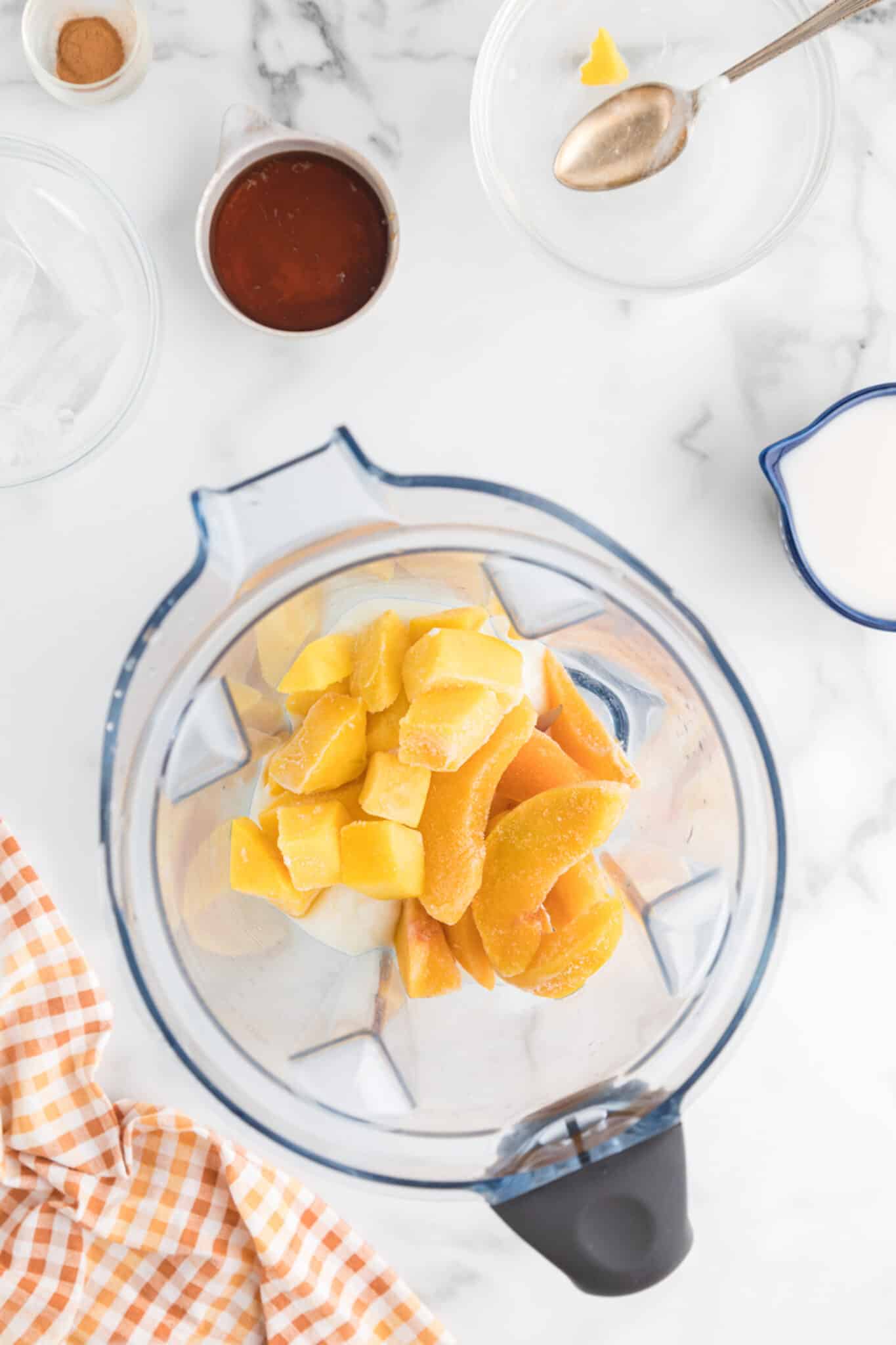 mango peach smoothie ingredients in blender.