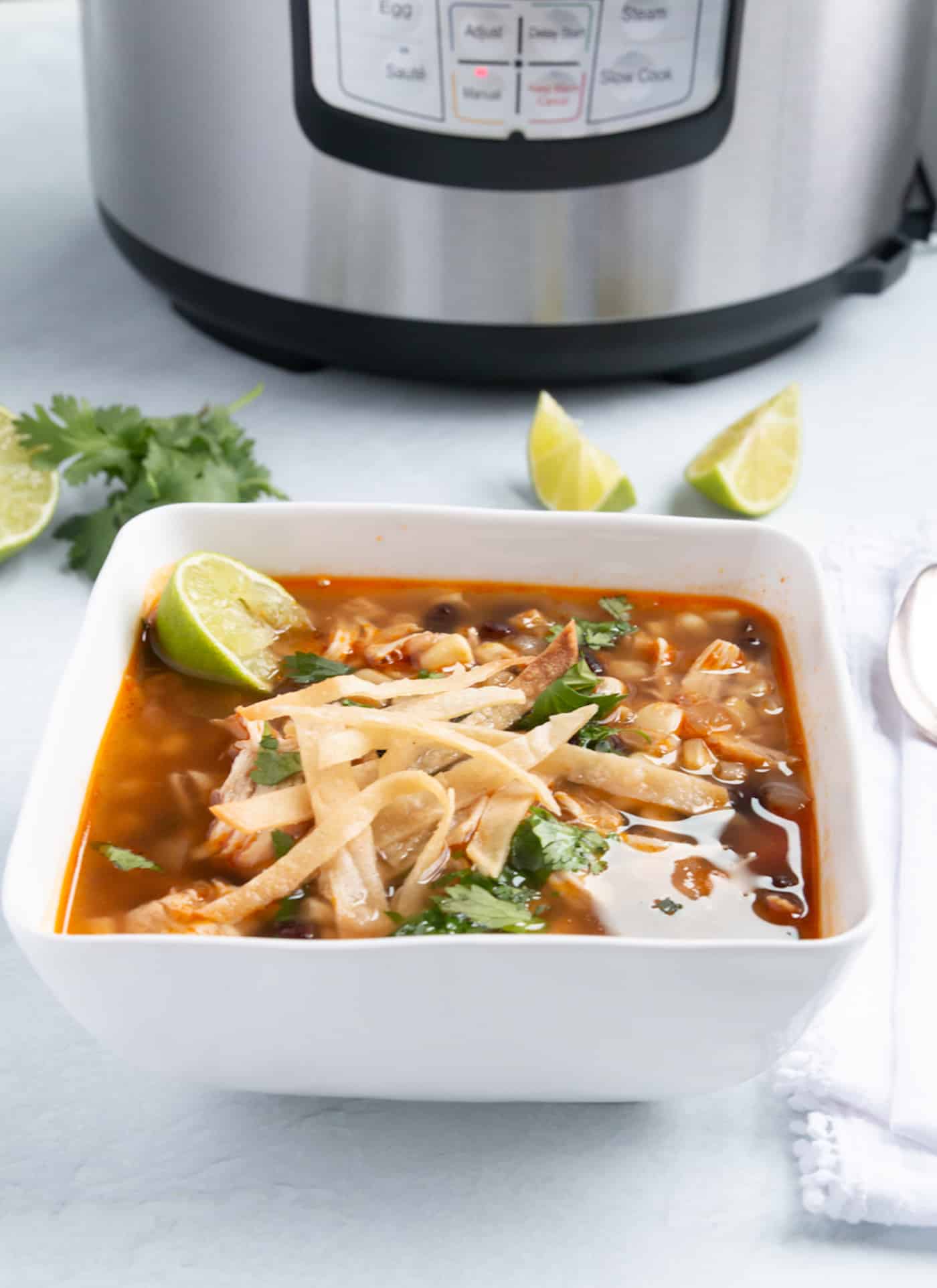 white bowl filled with instant pot chicken tortilla soup ready to eat.