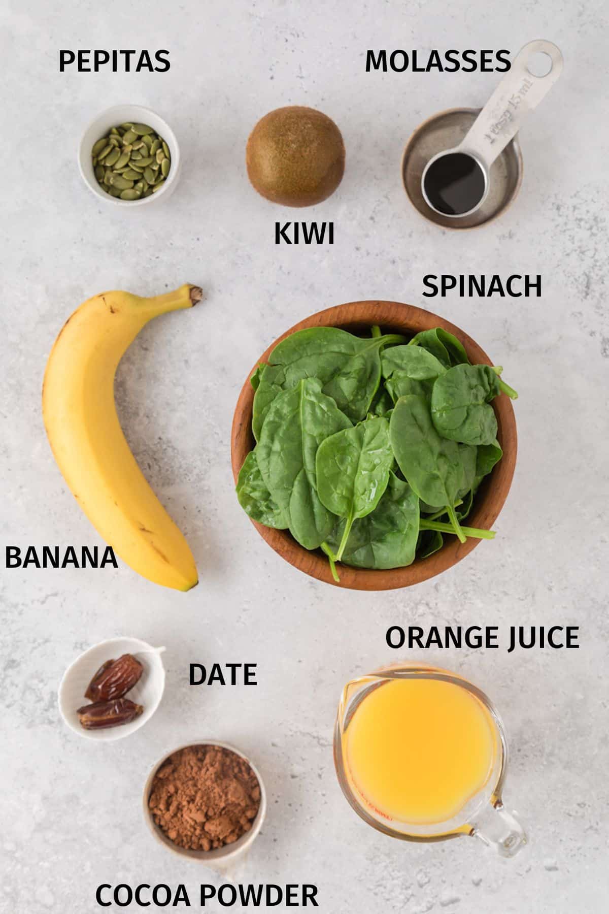 Ingredients to make an iron rich smoothie in small bowls on a white surface.