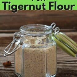 Jar of tigernut flour on wooden surface with tigernuts.