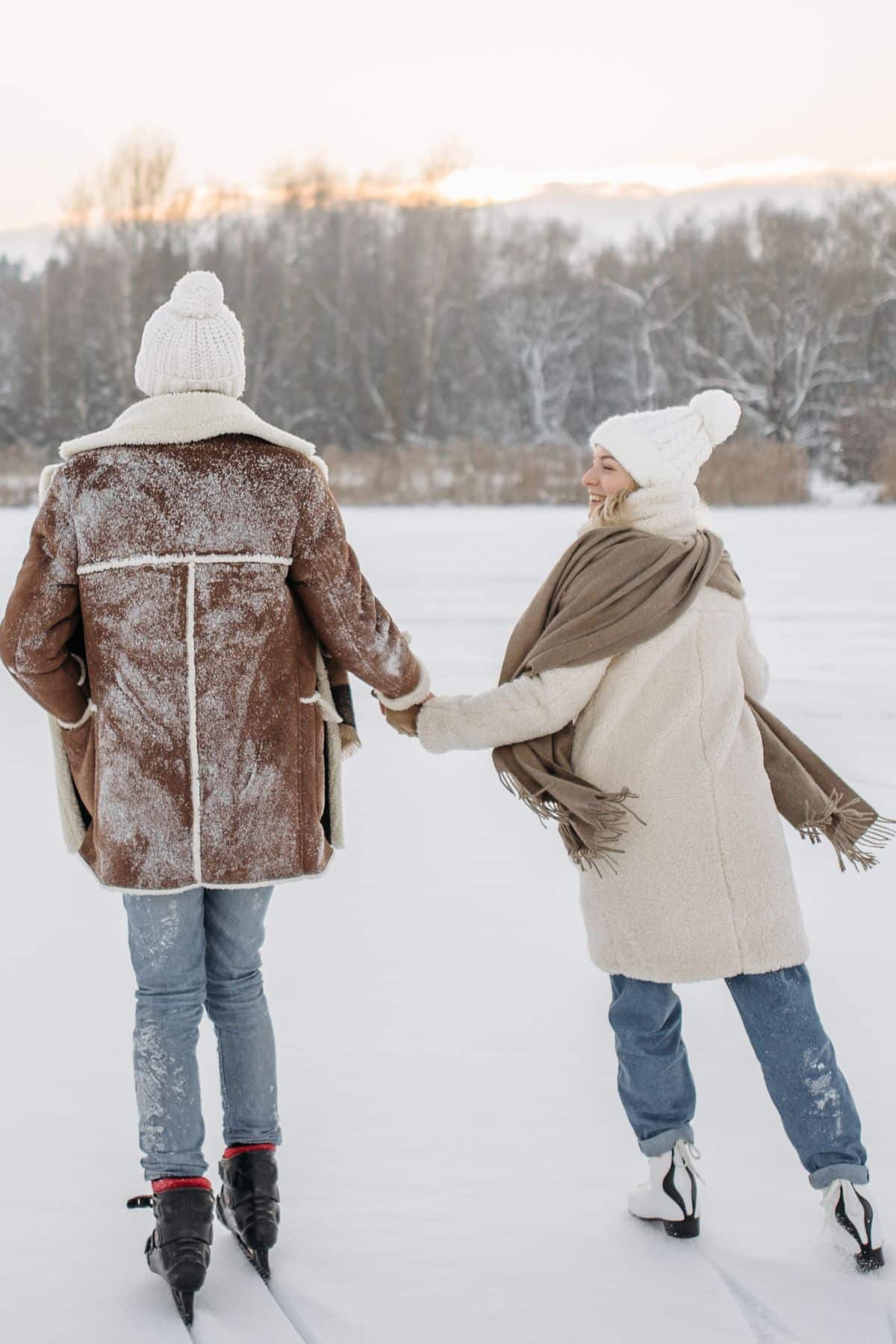 two people holding hands and ice skating.