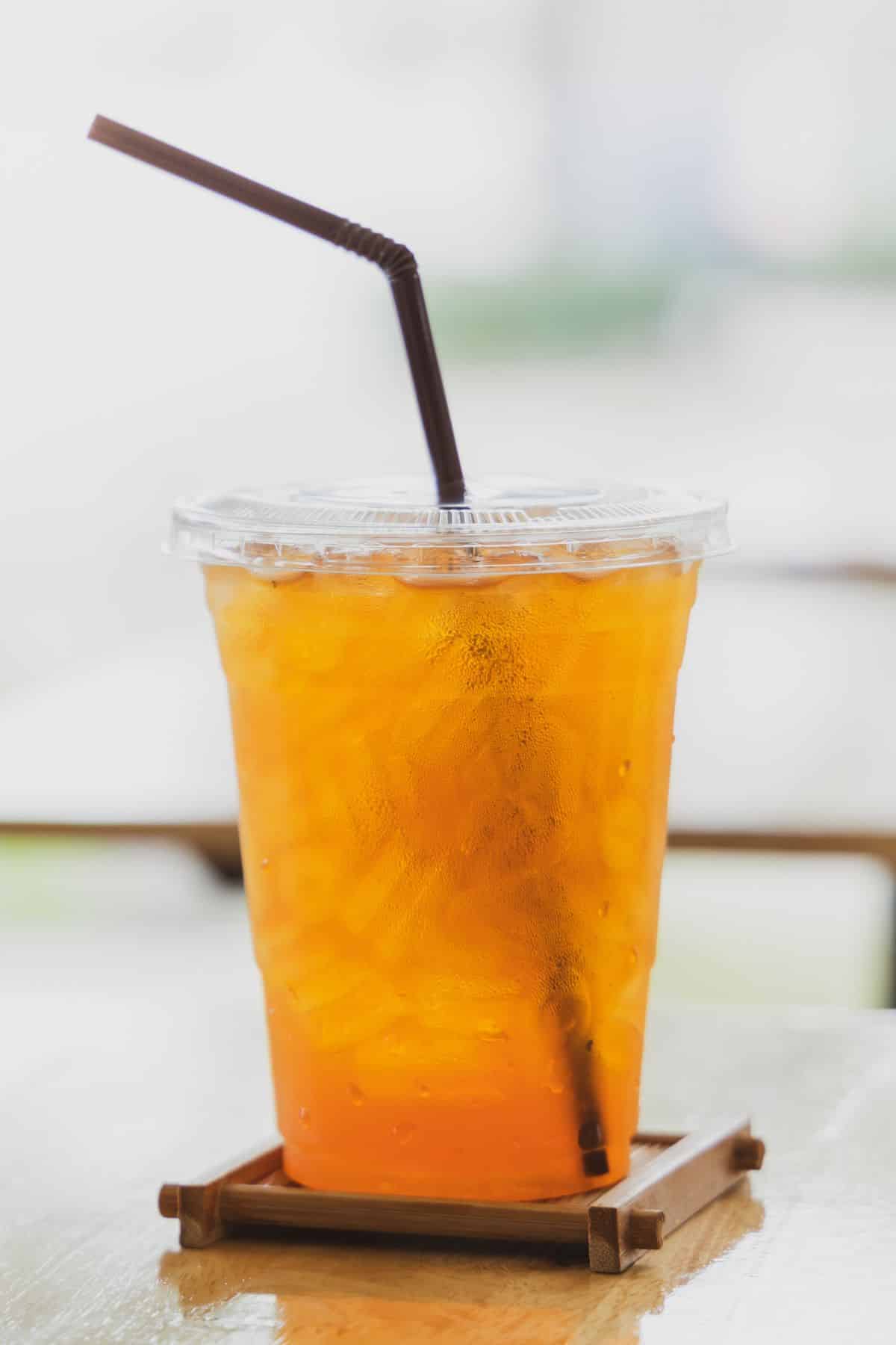 an Iced Peach Green Tea in a plastic cup.
