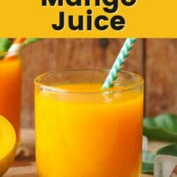 A short glass of mango carrot juice with a striped straw.