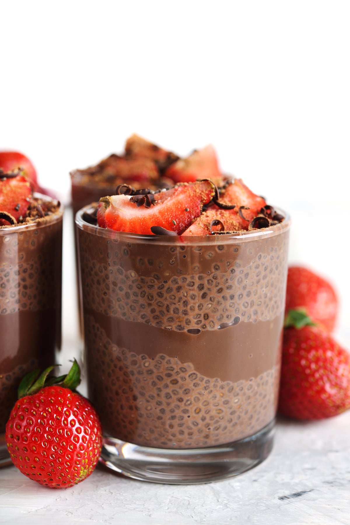 chocolate chia pudding with strawberries in glass on table.