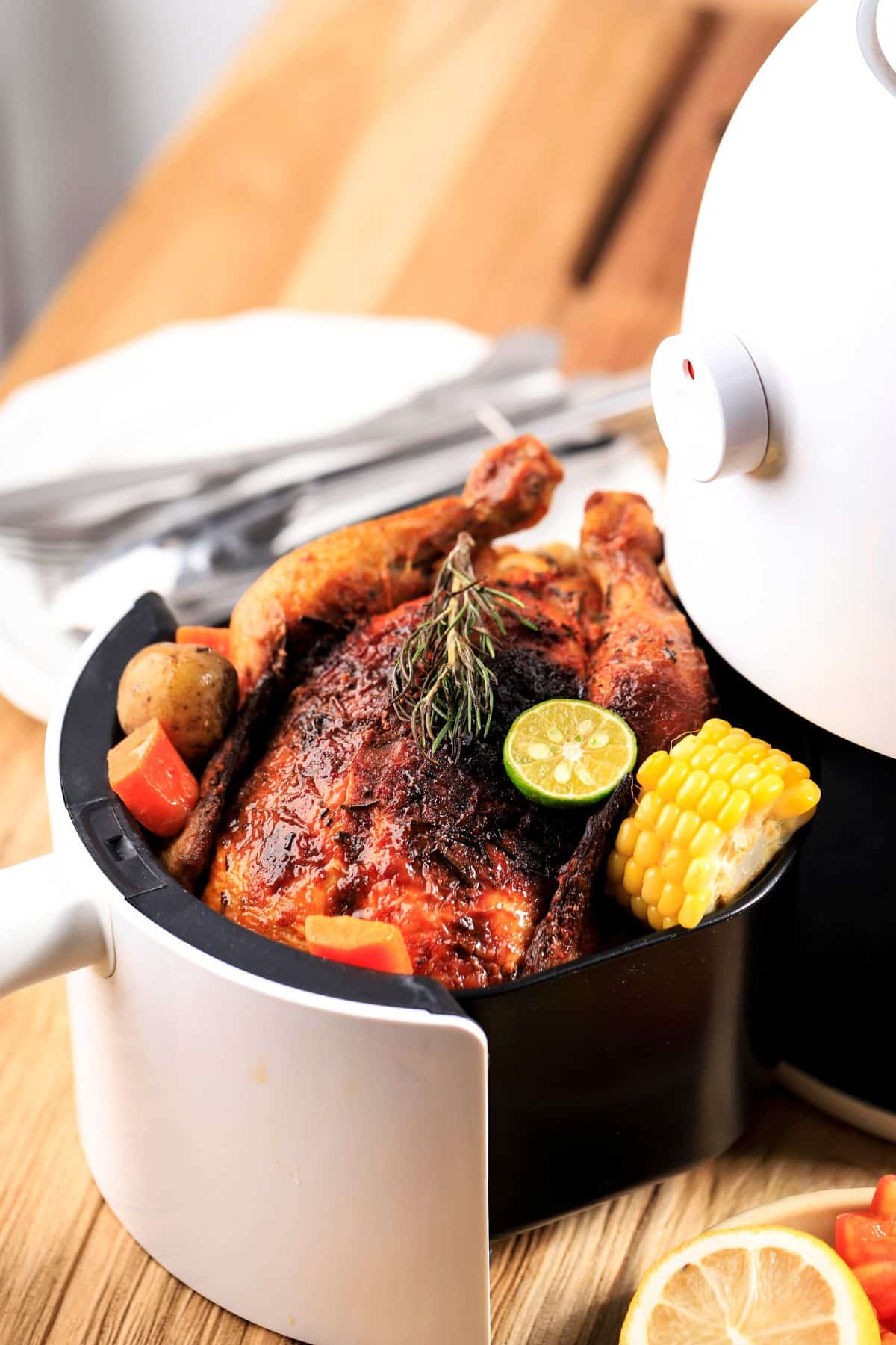 an air fryer with a whole, cooked chicken in the basket.