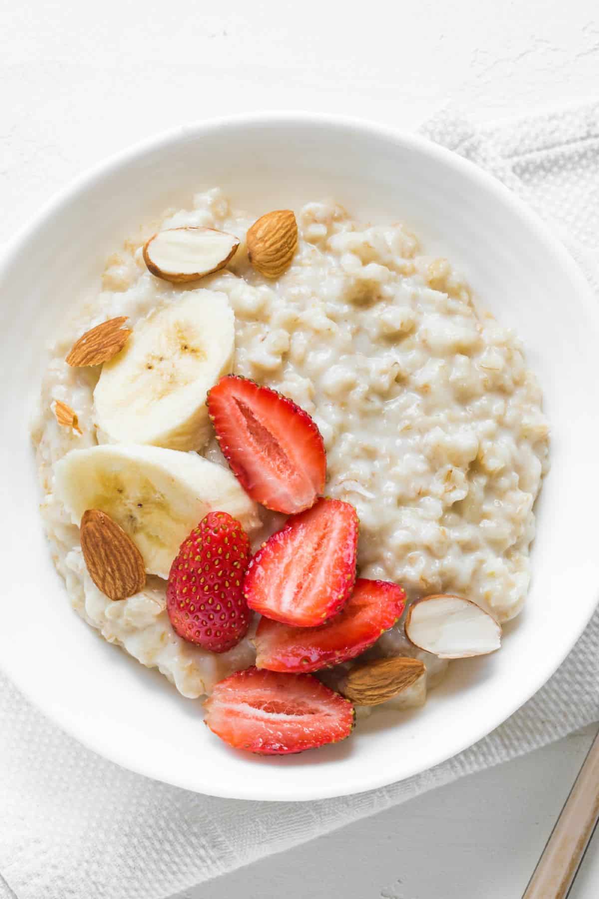 a bowl of oatmeal topped with bananas and strawberries.