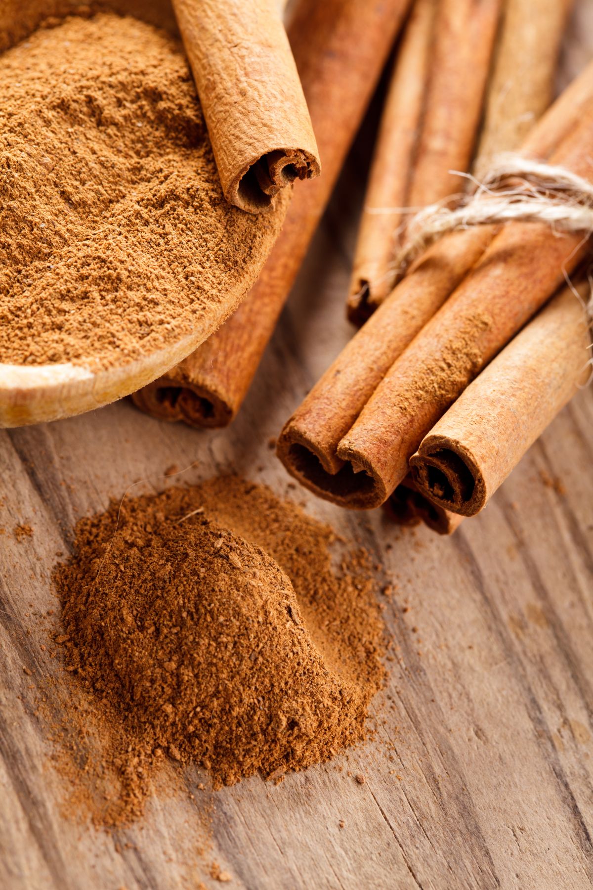 ground cinnamon spilling out of a wooden bowl.