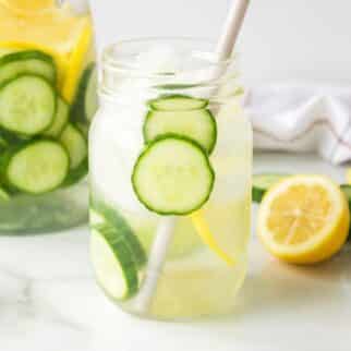 cucumber lemon drink in ball jar with straw.